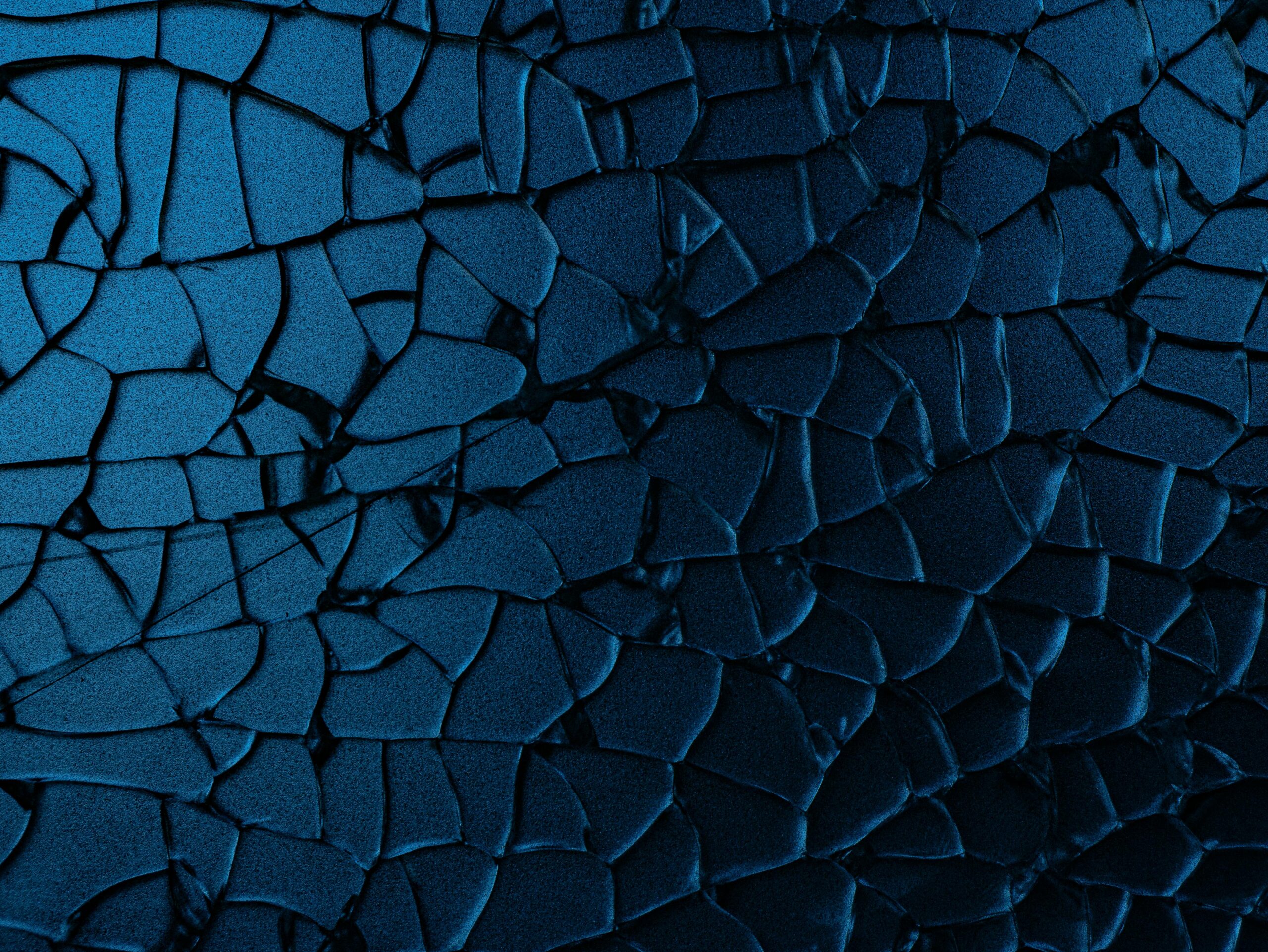 Close-up view of a cracked blue surface with abstract patterns and textures.